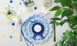 Blå tallrikar med en rosett som säger "Fy fan vad du är bra". Perfekt student dekoration inspiration med blommor och konfetti.