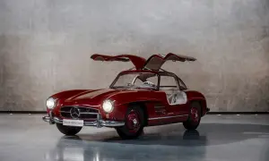 Czerwony Mercedes Gullwing z otwartymi drzwiami, ikona motoryzacji, prezentuje swoje klasyczne linie.