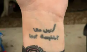 Tatuaz na opalonej skorze z napisem "Who would have thought?".