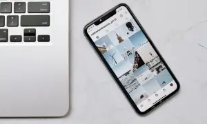 Telefon z Instagramem obok klawiatury laptopa. Dowiedz się, jak połączyć telefon z laptopem, aby łatwo przesyłać zdjęcia.