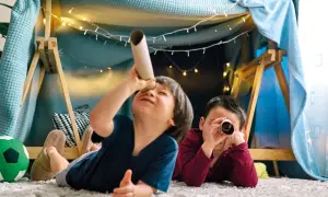 Zwei Jungen erkunden in einer gemütlichen Höhle mit Lichterketten ihre Welt. Perfekte Spiele ab 3 Jahre für fantasievolle Abenteuer.