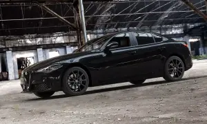 Czarny Alfa Romeo Giulia Quadrifoglio w opuszczonej hali przemysłowej.