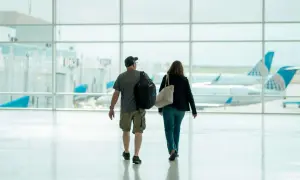 Para idzie przez lotnisko, w tle samoloty United Airlines. Może to ich pierwszy lot czeskimi liniami lotniczymi.