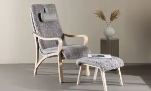 En bekväm trä fåtölj med grå fårskinnsklädsel och en matchande pall. Perfekt för en mysig läshörna.
