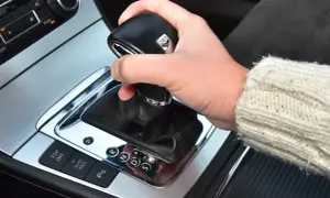 Dłoń na lewarku DSG, pokazująca jak jeździć automatem. Widoczne przyciski ESP, Auto Hold i wybór biegów P, R, N, D, S.