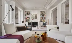 Elegante salón con sofás blancos, chimenea y estanterías, un ejemplo de un estudio de arquitectura e interiorismo.