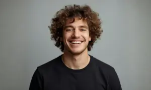 Uomo sorridente con splendidi capelli ricci uomo, un look naturale e vivace.