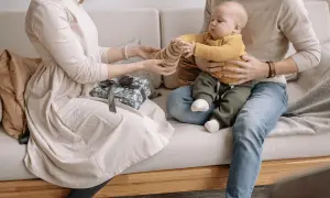 Un couple heureux profite de son enfant, un cadeau emballé à côté.