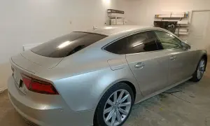 Srebrne Audi A7 z przyciemnione szyby stoi w garażu.