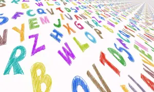 Kolorowe, kredowe litery tworzą wzór na białym tle. Widać wielką literę w druku, jak "R" i "B", a także inne znaki alfabetu.
