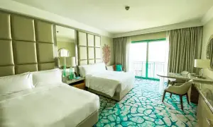 Pokój hotelowy z dwoma łóżkami i dywanem w kolorze mokrej wody.