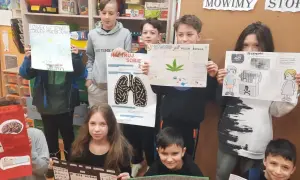 Dzieci prezentują plakaty o szkodliwości używek, pokazując jak zrobić projekt artystyczno-edukacyjny.