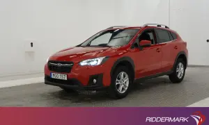 A red Subaru XV parked indoors, with its headlights on.