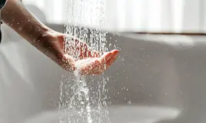 Hand fängt Wasser auf. Mögliche Legionellen im Wasser können zu einer Mietminderung führen.