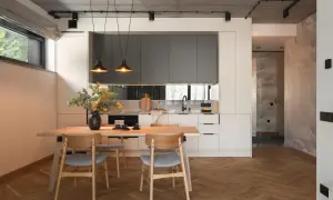 Nowoczesna kuchnia z jadalnią, gdzie beton, drewno i szarość tworzą minimalistyczne wnętrze. Różne style wnętrz można tu odnaleźć.