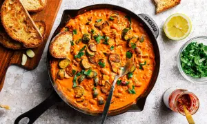 Herzhafte zucchini pfanne in cremiger Sauce, garniert mit frischer Petersilie und serviert mit geröstetem Brot.