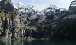Majestatyczne Tatry Wysokie, ośnieżone szczyty odbijające się w spokojnej tafli jeziora.