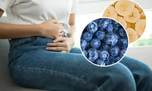 Osoba z bólem brzucha, sugerującym wodnistą biegunkę, obok borówek i plasterków banana.