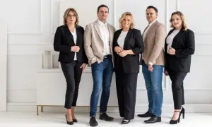 Pięć osób w garniturach stoi obok siebie na białym tle.
