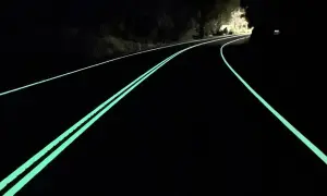 Route de nuit avec marquage lumineux vert, un logo marquage ce discret sur le côté.