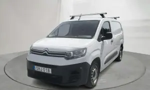 Vit Citroën Berlingo, en pålitlig begagnad transportbil med takräcke, redo för nya äventyr.