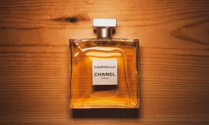 Elegancka butelka perfum Chanel Gabrielle na drewnianym tle. Czy to właśnie takich perfum używają gwiazdy?