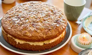 Ein köstlicher Bienenstich Kuchen, bedeckt mit gerösteten Mandelblättchen, wartet auf sein Bienenstich Rezept.