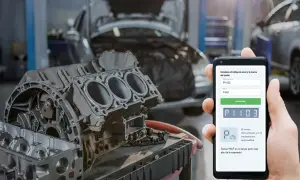 Mecánico revisa código P1103 en su móvil para Ford Transit. Motor desarmado en taller.