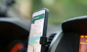Telefon z mapą na ekranie, zamontowany w samochodzie. Ułatwia nawigację na telefon podczas podróży.