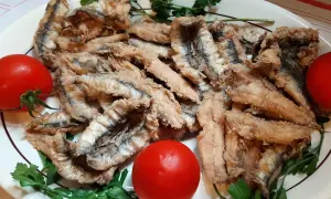 Chrupiące filet anchois z sardeli, podane z pomidorami i natką pietruszki. Pyszna przekąska.