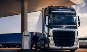 Un chauffeur s'apprête à faire le plein de carburant poids lourd pour son camion Volvo, sous un ciel nuageux.
