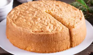 Un soffice angel cake altissima, pronto per essere decorato. La sua consistenza ariosa promette un sapore leggero e delizioso.
