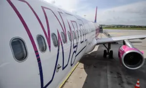 Samolot Wizzair, znanej firmy lotniczej, na płycie lotniska. Różowe logo i silnik.
