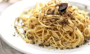 En tallrik med spaghetti, generöst toppad med finriven tryffel. Perfekt för en lyxig middag med ett gott vin till tryffelpasta.