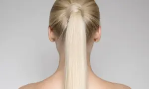 Vista posteriore di una donna con una perfetta coda di cavallo alta bionda, liscia e lucida.