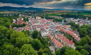 Malownicze polskie Carcassonne z dominującą wieżą kościelną, otoczone zielenią i górami.