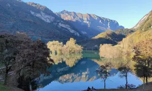 Splendido lago di Tenno in giornata, con montagne maestose e riflessi sull'acqua cristallina. Un angolo di pace autunnale.