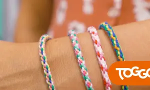 Bunte Freundschaftsarmbänder, die man leicht selber machen kann, zieren einen Arm.