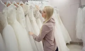 Blondynka wybiera suknię ślubną w salonie sukien ślubnych.