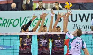 Siatkarze walczą o piłkę przy siatce. Emocjonujący moment z meczu, przypominający zmagania na igrzyska olimpijskie siatkówka.