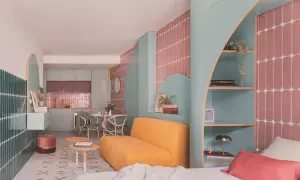Un espacio moderno y colorido, ideal para saber como dar luz a una planta baja. Muebles curvos, estanterías y azulejos vibrantes crean un ambiente acogedor.