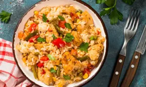 Pyszne risotto z kurczakiem, warzywami i ziołami w misce, gotowe do podania.