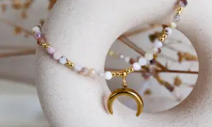 Delikatna bransoletka z kamieni, w tym opal, symbolizująca spokój i intuicję, z zawieszką w kształcie złotego księżyca.