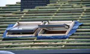 Dach prefabrykowany w budowie, z widocznymi oknami dachowymi i drewnianą konstrukcją.