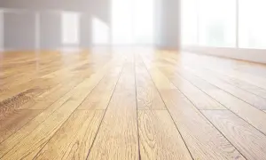 Pavimento in legno massiccio, con venature naturali che riflettono la luce. Un ambiente luminoso e accogliente.