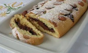 Ciambellone marchigiano con ripieno goloso di Nutella, decorato con mandorle e zucchero a velo.