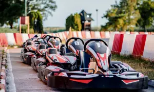 Rząd gokartów czeka na torze w Redzie. Gotowe do wyścigu, z numerami 3, 8 i 1 na czele.