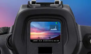 Il mirino elettronico mostra un tramonto mozzafiato sul mare, con impostazioni di scatto e istogramma.