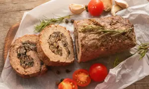 Pyszna rolada z mięsa mielonego z grzybami, podana z pomidorkami i rozmarynem.