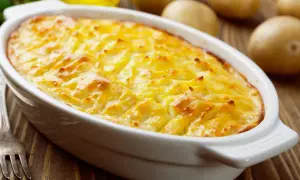 Herzhaftes Kartoffelgratin mit gekochten Kartoffeln, goldbraun überbacken, bereit zum Servieren.